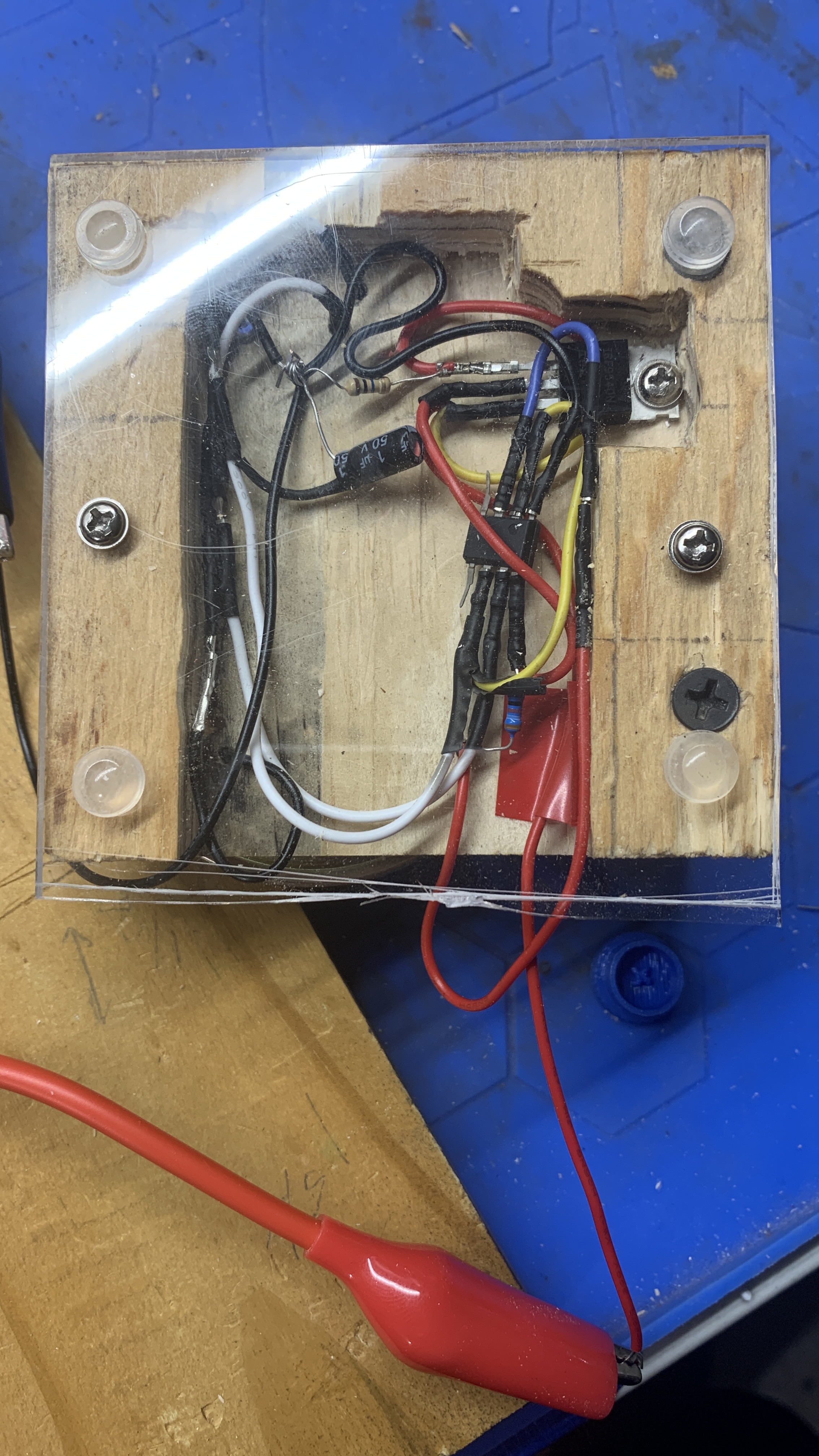 Picture of a block of wood, with a false bottom housing many wires and small electronics